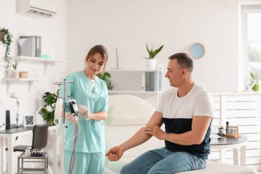 Klinikte kan bağışı yaptıktan sonra hemşirenin yanında yetişkin bir adam.