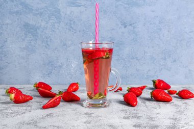 Gri masada bir bardak lezzetli çilek suyu.