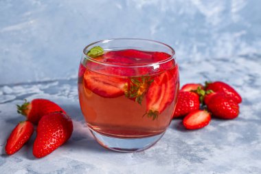 Mavi masada bir bardak lezzetli çilek suyu.