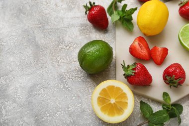 Limonlu taze çilek ve gri arka planda nane şekeri.