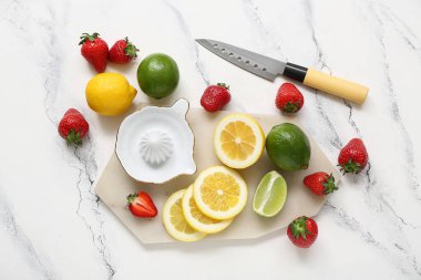 Beyaz arka planda çilekli limonata hazırlamak için meyve sıkacağı ve malzemelerden kurulu.
