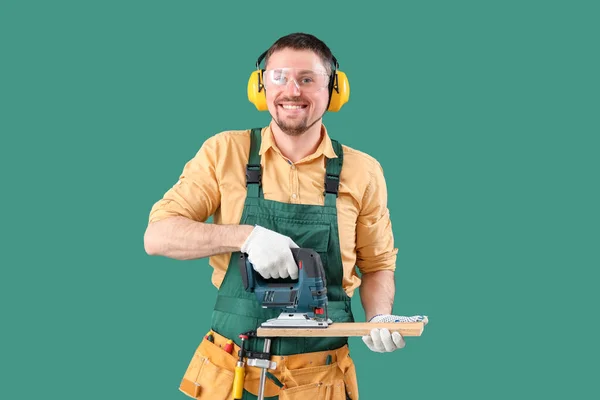 Homem Carpinteiro Serrar Prancha Madeira Com Quebra Cabeça Fundo Verde — Fotografia de Stock