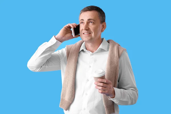 Reifer Mann Mit Tasse Kaffee Gespräch Handy Auf Blauem Hintergrund — Stockfoto