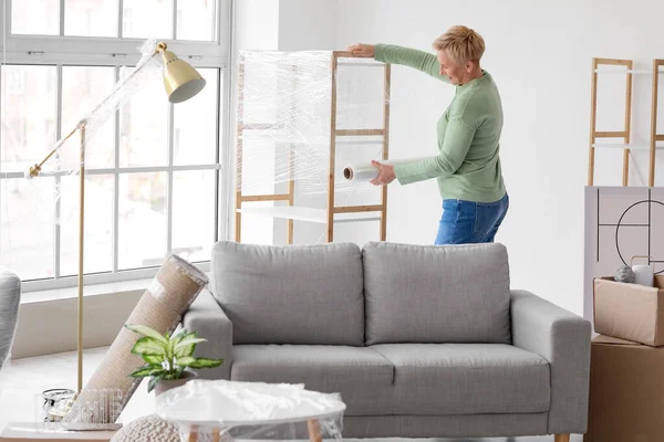 Mature Woman Wrapping Shelving Unit Stretch Film Home — Stock Photo, Image