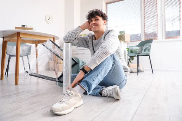 Geniş Ambalajlı Genç Adam Mutfakta Oturuyor — Stok fotoğraf