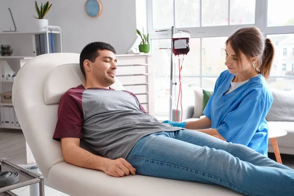 Enfermera Tomando Sangre Donante Joven Clínica —  Fotos de Stock