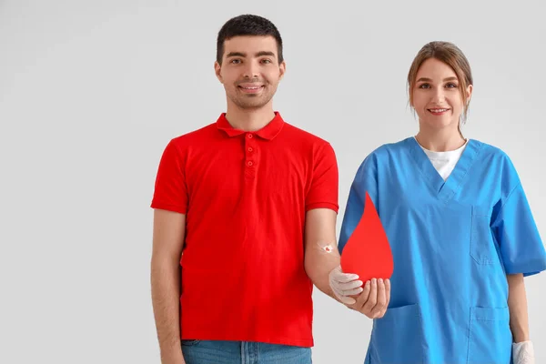 Junge Blutspenderin Und Krankenschwester Mit Papiertropfen Auf Hellem Hintergrund — Stockfoto
