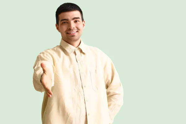 Junger Mann Reicht Handschlag Auf Grünem Hintergrund — Stockfoto
