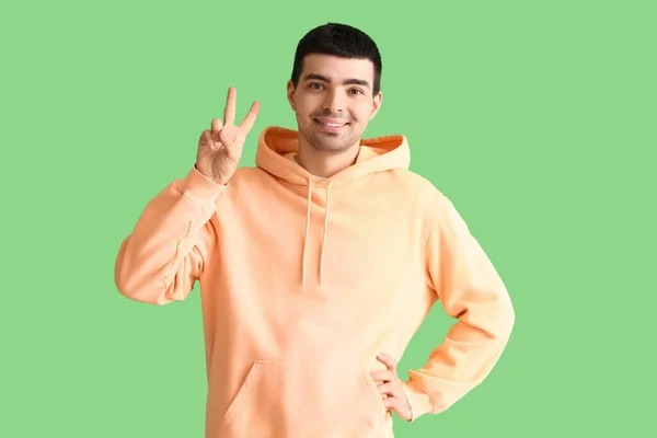 Young Man Showing Victory Gesture Green Background — Stock Photo, Image