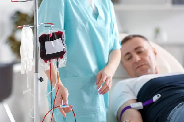 診療所で成熟したドナーから血液を採取する女性看護師 — ストック写真