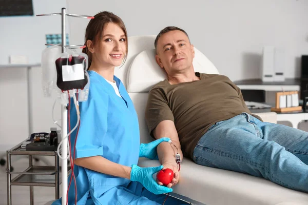 诊所的女护士从成熟的捐献者身上取血 — 图库照片