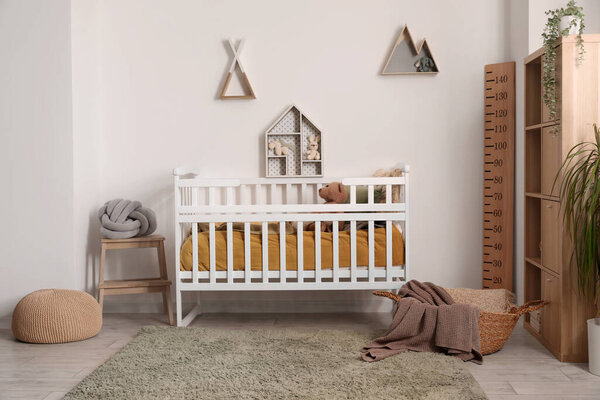 Interior of children's bedroom with crib, shelves and toys