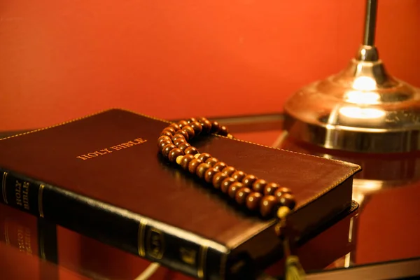 Bibeln Med Bönepärlor Bordet Nära Röd Vägg — Stockfoto