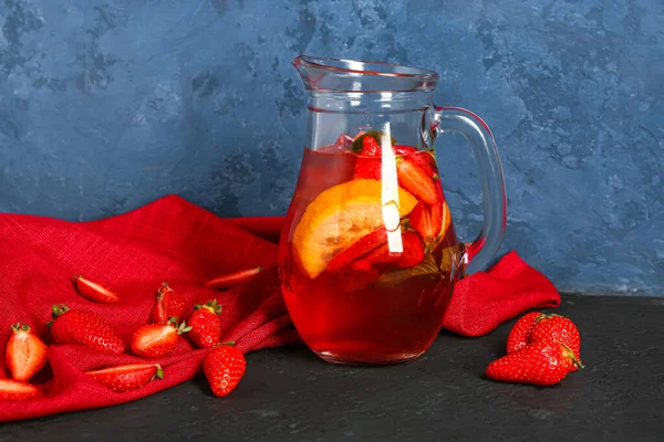 stock image Jug of tasty strawberry juice on black table