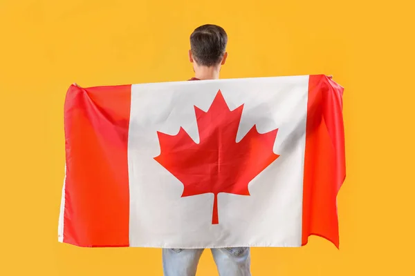Bonito Homem Com Bandeira Canadá Fundo Amarelo Visão Traseira — Fotografia de Stock