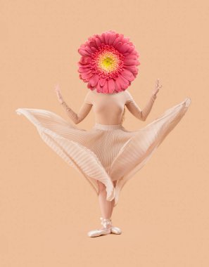Bej arka planda başı yerine Gerbera çiçeğiyle dans eden kadın.