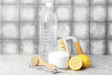 Bir kase kabartma tozu, sirke, temizlik fırçası ve limon.