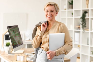 Dizüstü bilgisayarı olan olgun bir kadın programcı.