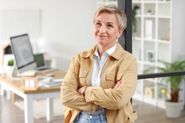 Ofiste düşünceli olgun bir kadın var.