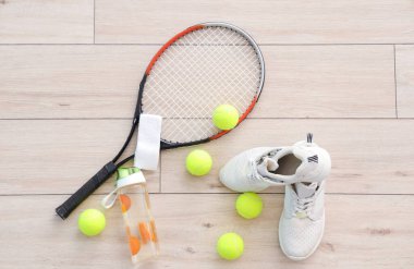 Beyaz tahta arka planda spor erkek spor ayakkabıları ve tenis aksesuarları.