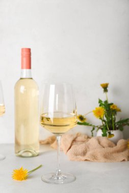 Beyaz masada bir şişe karahindiba şarabı.