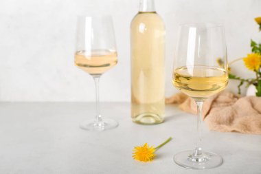 Beyaz masada bir şişe karahindiba şarabı.