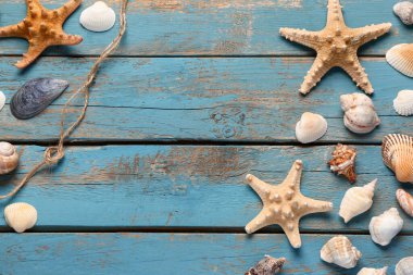 Deniz kabuklarını ve mavi ahşap zemin üzerine starfishes