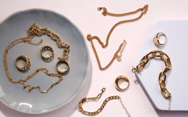 Tabak ve dekoratif podyum beyaz arka planda altın mücevherler