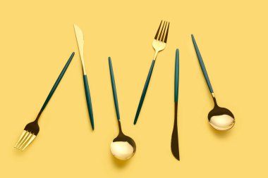 Sarı arkaplanda şık çatal bıçak takımı