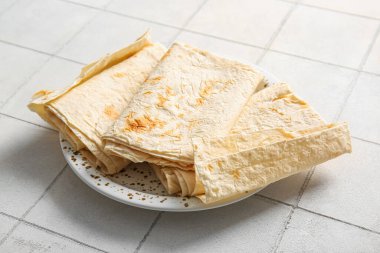 Beyaz fayans zemininde taze lavaş tabağı.