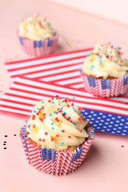 Pembe arka planda ABD bayrakları olan lezzetli vatansever kapkekler. Amerikan Bağımsızlık Günü