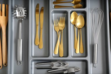 Farklı altın çatal bıçaklarla mutfak çekmecesini aç.