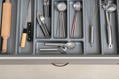 Farklı gümüş çatal bıçaklarla mutfak çekmecesini aç