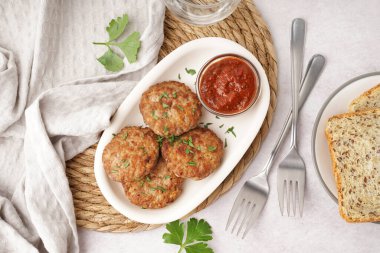 Maydanozlu pirzola, ketçap ve çatallar mutfakta beyaz grunge masasında.