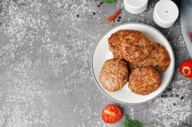 Mutfaktaki grunge masasında pirzola, domates ve biber tabağı.