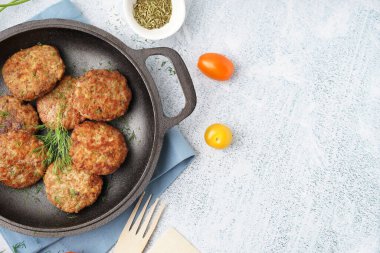 Mutfaktaki mavi grunge masasında pirzola, dereotu ve domatesli kızartma tavası.