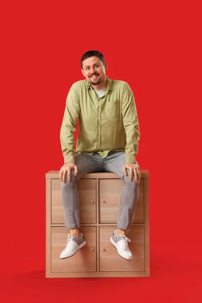 Handsome Man Sitting Big Blank Poster Red Background — Stock Photo, Image