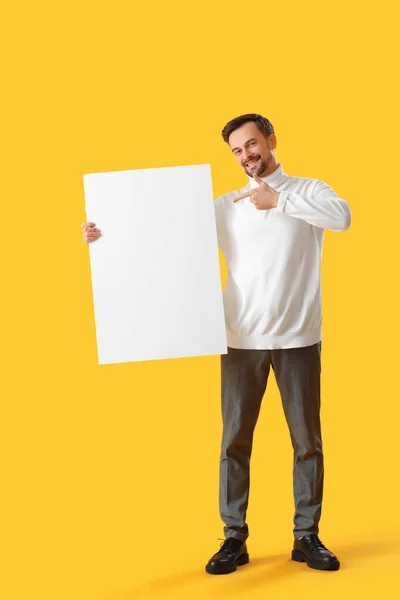 Hezký Muž Ukazuje Velký Prázdný Plakát Žlutém Pozadí — Stock fotografie