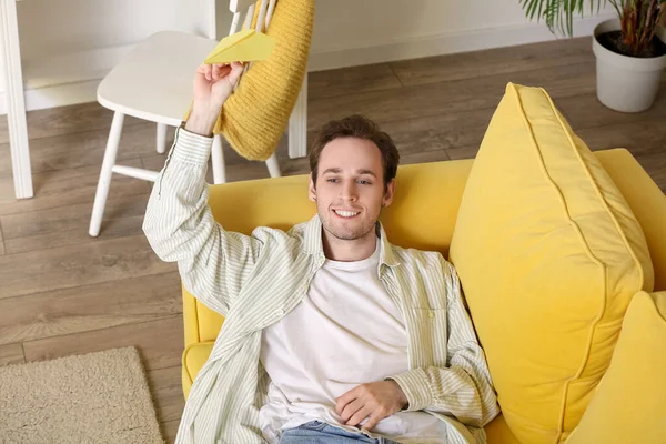 Young Man Paper Plane Lying Sofa Home — Stock Photo, Image