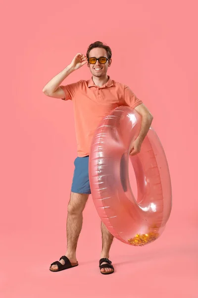 Jongeman Met Opblaasbare Ring Roze Achtergrond — Stockfoto