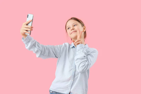 Cep Telefonlu Küçük Bir Kız Pembe Arka Planda Sohbet Ediyor — Stok fotoğraf