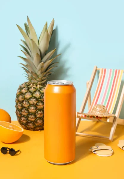 青い壁の近くのテーブルの上にビーチの装飾や果物を持つソーダの缶 — ストック写真