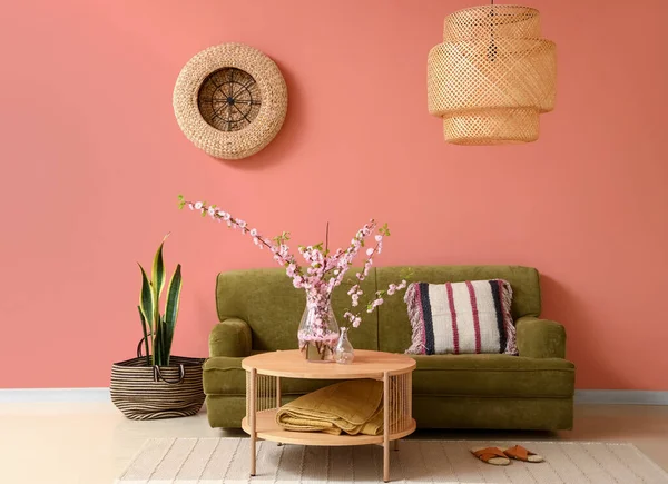 舒适的客厅里 有绿色的沙发 茶几上有盛开的樱花枝条 — 图库照片