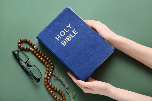 Mãos Femininas Com Bíblia Sagrada Óculos Contas Oração Fundo Verde — Fotografia de Stock