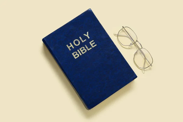 淡い黄色の背景に眼鏡をかけた聖書 — ストック写真