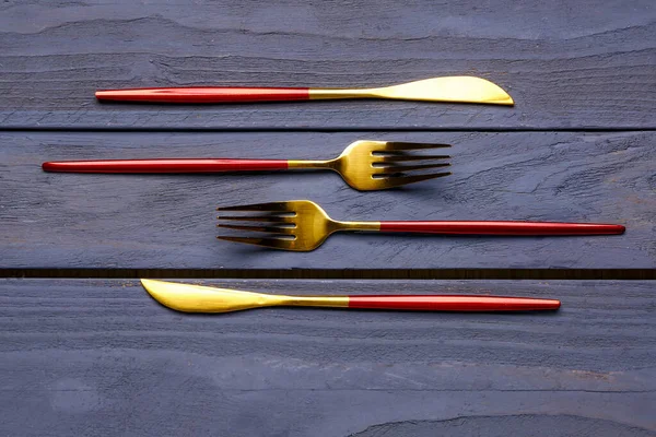 Golden Forks Knives Red Handles Blue Wooden Background — Stock Photo, Image