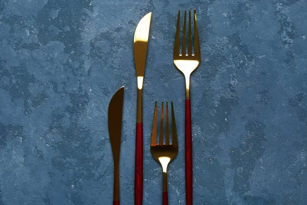 Golden Forks Knives Red Handles Blue Background — Stock Photo, Image
