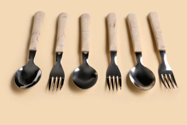 Stainless Steel Forks Spoons Plastic Handles Beige Background — Stock Photo, Image