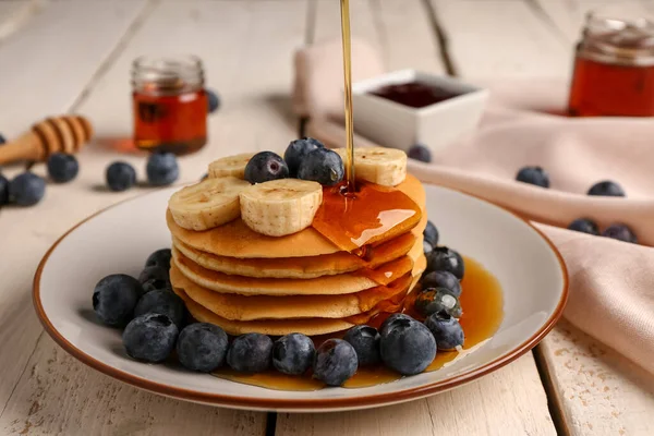 Menuang Madu Pancake Lezat Dengan Pisang Dan Blueberry Pada Latar — Stok Foto