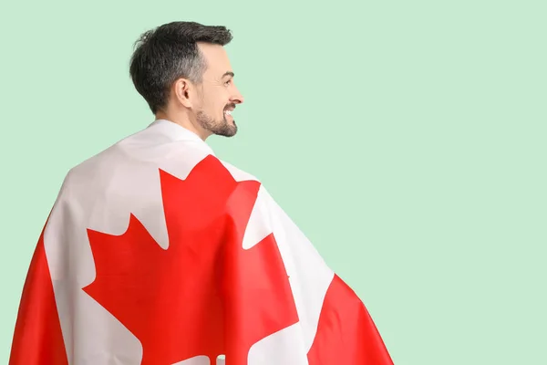 Yeşil Arka Planda Kanada Bayrağı Taşıyan Yakışıklı Bir Adam — Stok fotoğraf